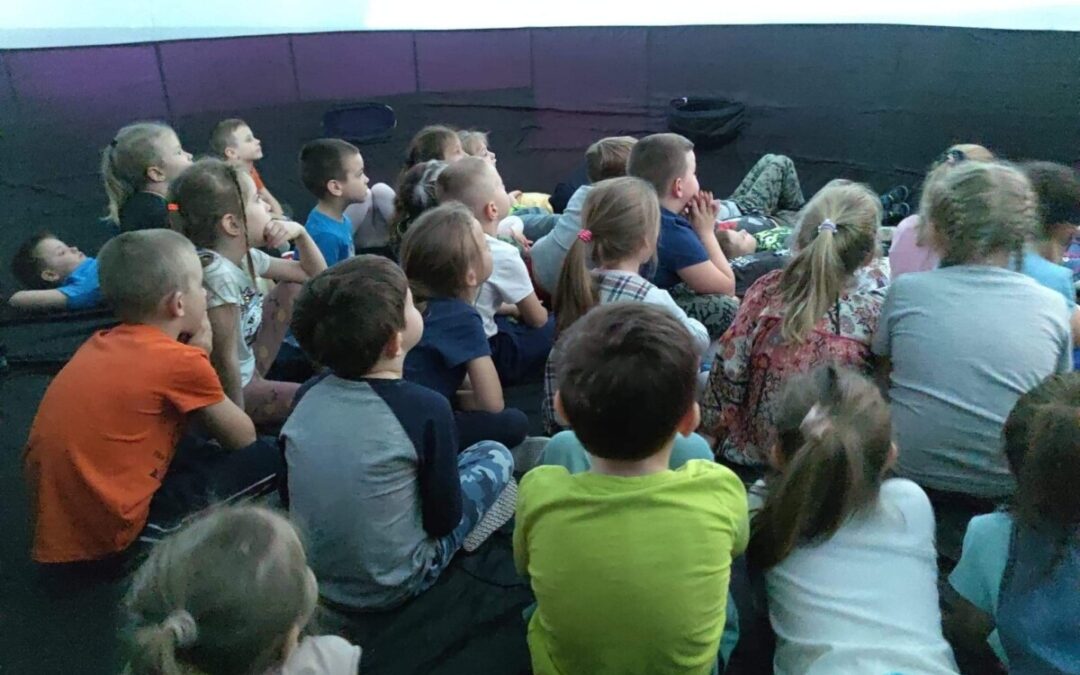 Dzieci znajdują się w środku mobilnego planetarium.
