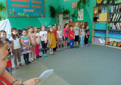 Dzieci w półkolu śpiewają piosenkę