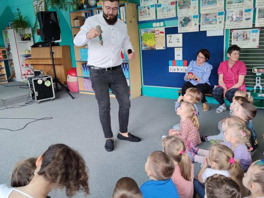 Dzieci w sali przedszkolenj ogladają prezentowany mikrofon.