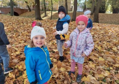 dzieci zbierają liście w parku